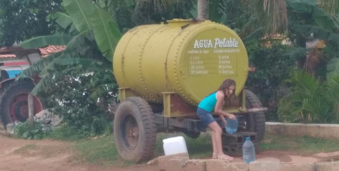 Niña recoge agua de un camión